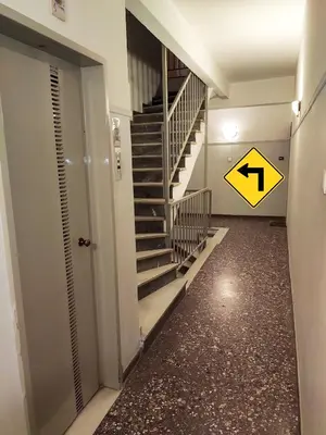 a hallway with a staircase and a sign on the floor at Modern studio Chiou in Athens