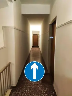 an empty hallway with a blue arrow sign on the floor at Modern studio Chiou in Athens