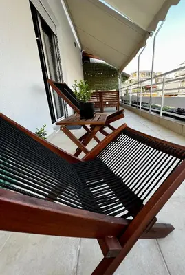 a bench on a balcony with a table and a plant at PSH -Stylish Quiet Top Floor Apt- Near Acropolis in Athens