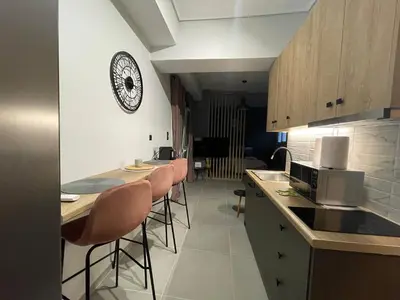 a kitchen with bar stools and a clock on the wall at PSH -Stylish Quiet Top Floor Apt- Near Acropolis in Athens