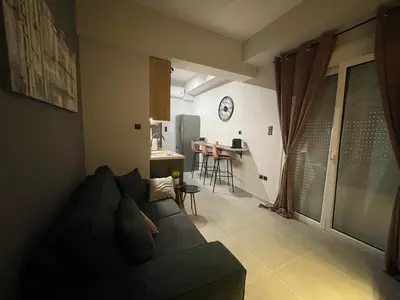 a living room with a couch and a kitchen at PSH -Stylish Quiet Top Floor Apt- Near Acropolis in Athens