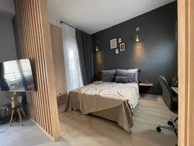 a bedroom with a bed and a flat screen tv at PSH -Stylish Quiet Top Floor Apt- Near Acropolis in Athens