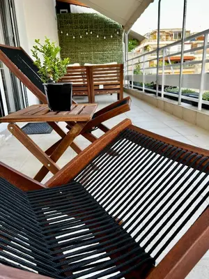 a chair and a table on a balcony with a plant at PSH -Stylish Quiet Top Floor Apt- Near Acropolis in Athens