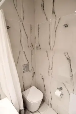 a white bathroom with a toilet and a shower at Cozy apartment in Palaio Faliro with a great view (D2) in Athens