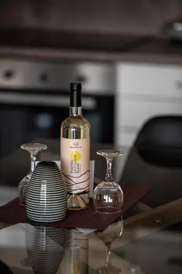 a bottle of wine and two glasses on a table at Cozy apartment in Palaio Faliro with a great view (D2) in Athens