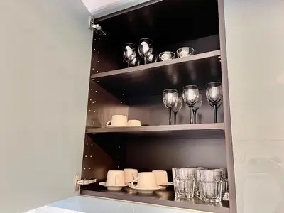 a cupboard with glasses and wine glasses at Lycabettus Luxury Cave greendom in Athens