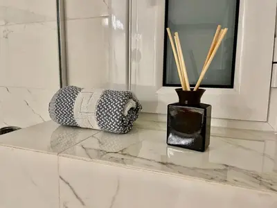 a white marble counter with a vase with bamboo sticks at Lycabettus Luxury Cave greendom in Athens