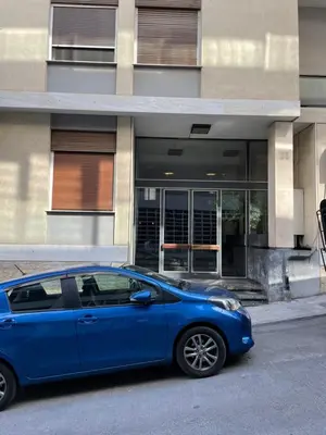 a blue car parked in front of a building at Lycabettus Luxury Cave greendom in Athens