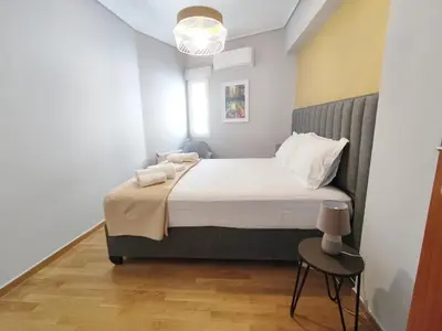 a bedroom with a large bed with a chair at Acropolis Veranda by YHA in Athens
