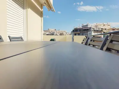 a large table on a balcony with chairs at Acropolis Veranda by YHA in Athens