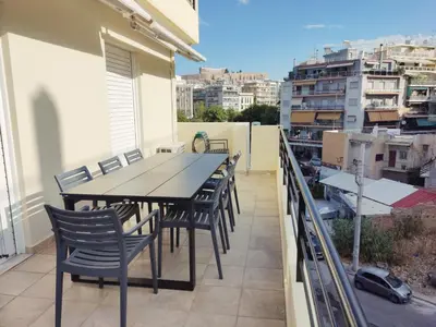 a table and chairs on the balcony of a building at Acropolis Veranda by YHA in Athens