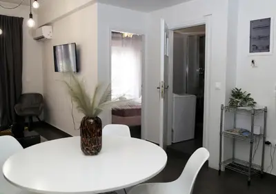 a white dining room with a white table and chairs at Monastiraki Sweet House 2 in Athens