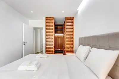 a bedroom with a white bed with towels on it at EvZin Homes Athens NEa Smyrni in Athens