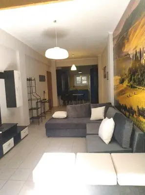 a living room with a couch and a painting on the wall at LG apartment bnb in Athens