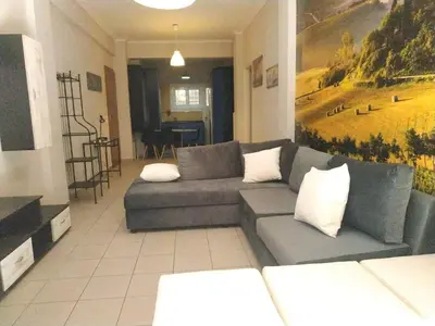 a living room with a gray couch and a table at LG apartment bnb in Athens