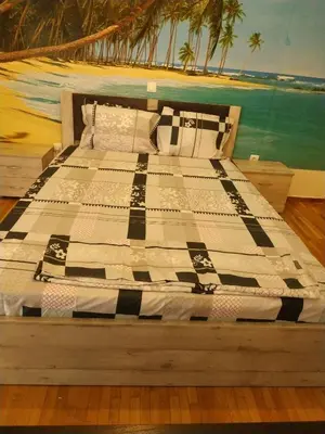 a bed with a black and white quilt on it at LG apartment bnb in Athens