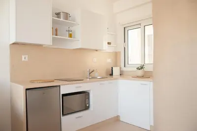 a white kitchen with a sink and a microwave at Private Jacuzzi & Acropolis View - The Suite in Athens