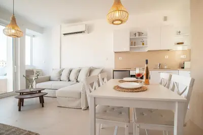 a living room with a table and a couch at Private Jacuzzi & Acropolis View - The Suite in Athens