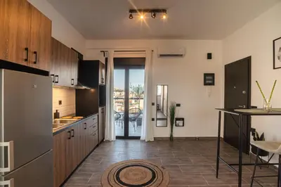 a kitchen with wooden cabinets and a door to a patio at Private Jacuzzi & Acropolis View - The Urban Loft in Athens