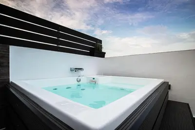 a large bath tub sitting on top of a building at Private Jacuzzi & Acropolis View - The Urban Loft in Athens