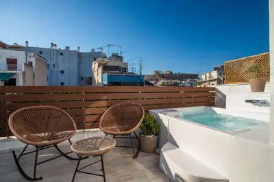 a balcony with two chairs and a hot tub at Private Jacuzzi & Acropolis View - The Athenian Loft in Athens