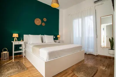 a bedroom with a white bed and a green wall at Private Jacuzzi & Acropolis View - The Athenian Loft in Athens