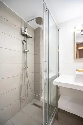 a bathroom with a glass shower and a sink at Evaggelismos m station studio for 3 pers by MPS in Athens
