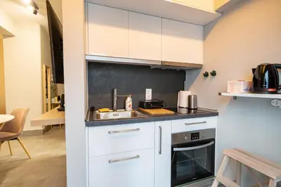 a kitchen with white cabinets and a sink at Evaggelismos m station studio for 3 pers by MPS in Athens