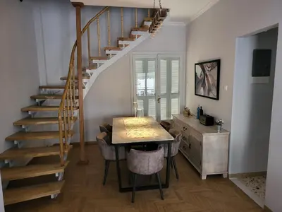 a dining room with a table and a staircase at Maria's Maisonette in Athens