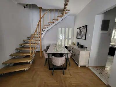 a dining room with a table and a staircase at Maria's Maisonette in Athens