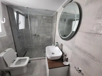 a bathroom with a toilet and a sink and a mirror at Maria's Maisonette in Athens