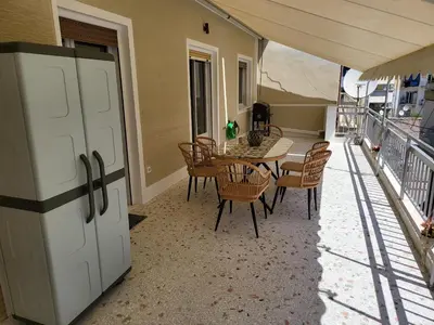 a dining room with a table and chairs on a balcony at Maria's Maisonette in Athens