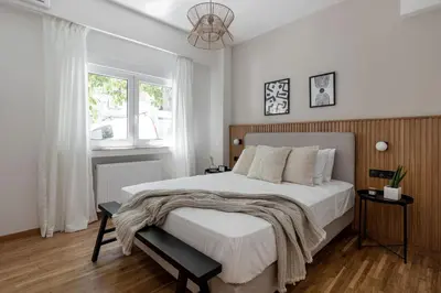 a bedroom with a large bed with white sheets and a window at Dreamy 1BR Apartment in Kolonaki by UPSTREET in Athens