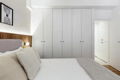a bedroom with a white bed and white cabinets at Dreamy 1BR Apartment in Kolonaki by UPSTREET in Athens