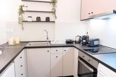 a kitchen with white cabinets and a sink at Syntagma Sweet House 2 in Athens
