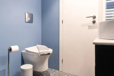 a bathroom with a white toilet and a blue wall at Syntagma Sweet House 2 in Athens