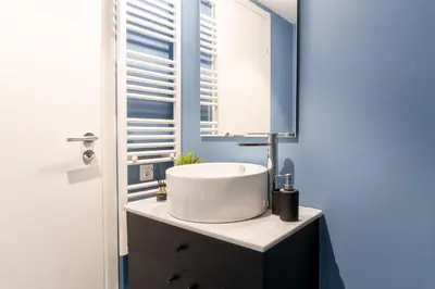 a bathroom with a white sink and a window at Syntagma Sweet House 2 in Athens