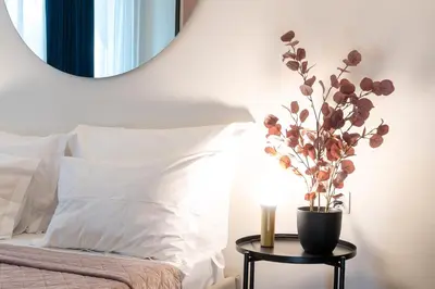 a mirror above a bed with a vase on a table at Syntagma Sweet House 2 in Athens