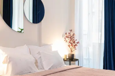 a bedroom with a bed with white pillows and a mirror at Syntagma Sweet House 3 in Athens