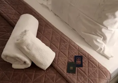 a white towel sitting on top of a bed at Syntagma Sweet House 3 in Athens