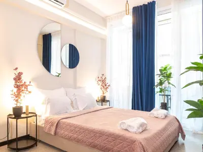 a bedroom with a large bed and a mirror at Syntagma Sweet House 4 in Athens