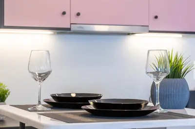 a table with two wine glasses and plates on it at Syntagma Sweet House 4 in Athens