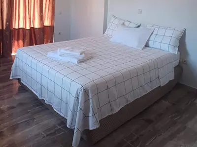 a bedroom with a large bed with white sheets at Glyfada-Elliniko in Athens