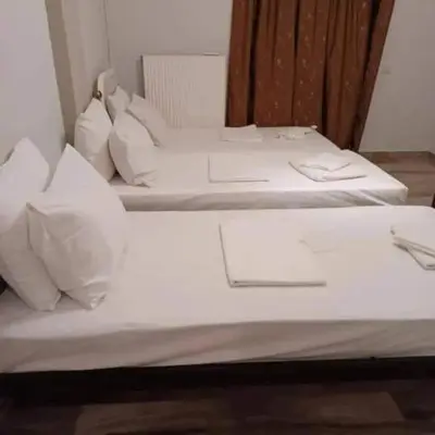 two beds in a room with white sheets and pillows at Glyfada-Elliniko in Athens
