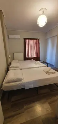 a bedroom with two beds and a window at Glyfada-Elliniko in Athens