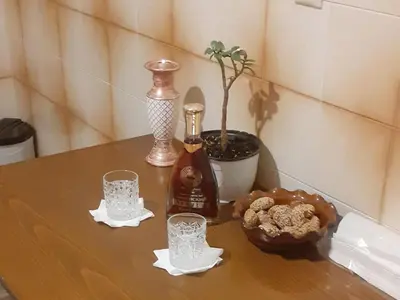 a table with a bottle of alcohol and two glasses at Glyfada-Elliniko in Athens