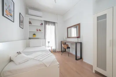a white bedroom with a bed and a desk at Noho apartments x Koukaki dikaiou 6 in Athens
