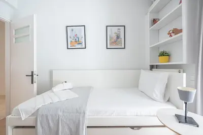 a white bedroom with a bed and a desk at Noho apartments x Koukaki dikaiou 6 in Athens