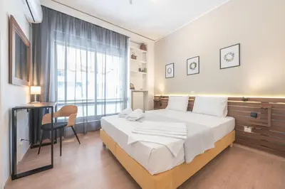a bedroom with a bed and a desk and a window at Noho apartments x Koukaki dikaiou 6 in Athens