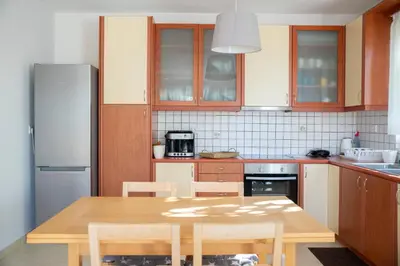 a kitchen with a wooden table and a refrigerator at Vasiliki's House in Porto Rafti